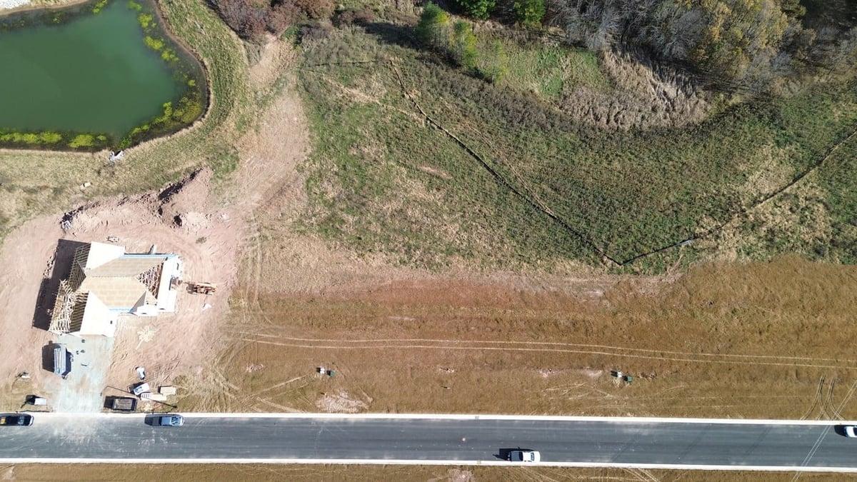 Overhead view of land for sale in De Pere, WI along paved road near new home construction