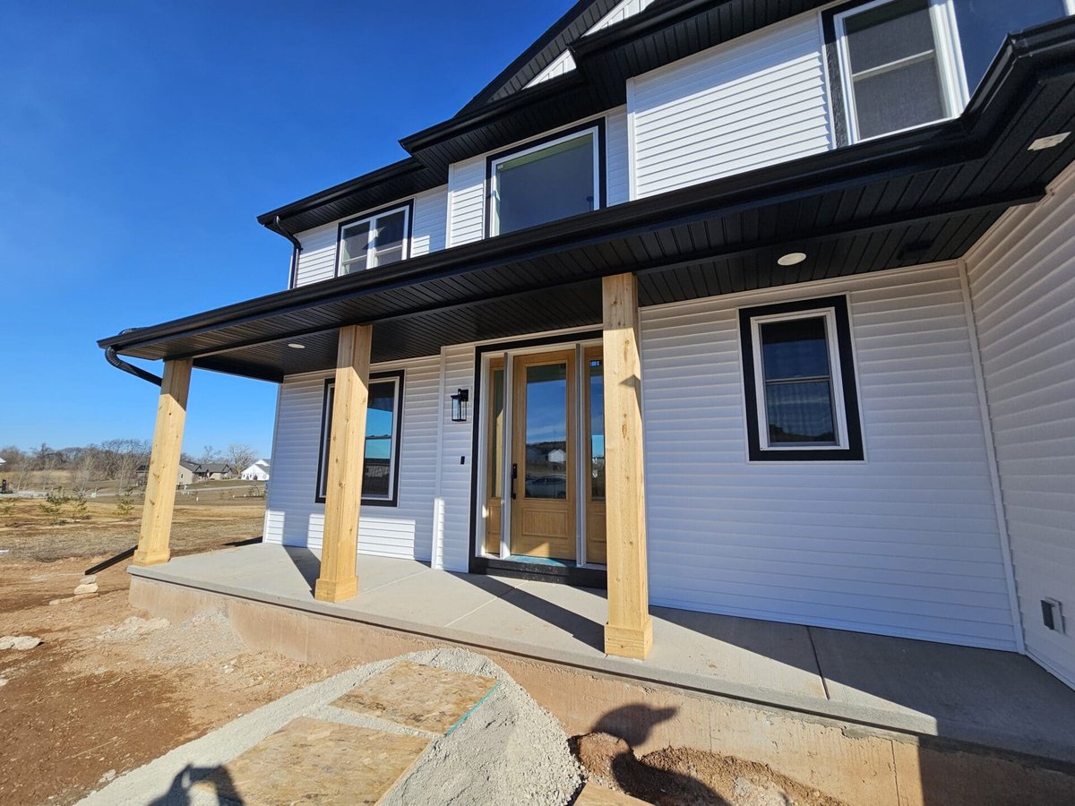 Covered front porch with wood posts, concrete slab, and modern farmhouse exterior in the Fox Cities
