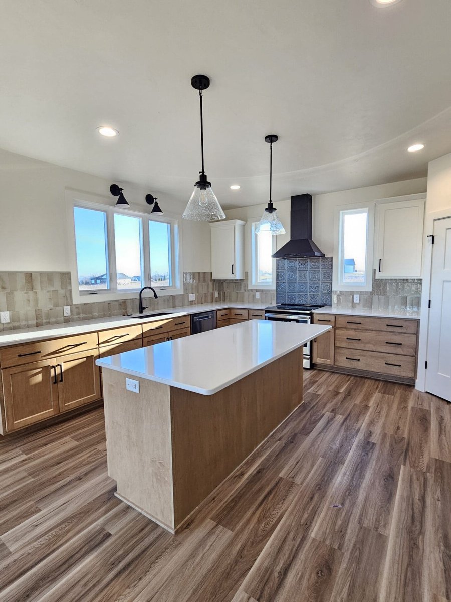 Modern kitchen angle showing island, tile backsplash, and stainless appliances in a Fox Cities residence