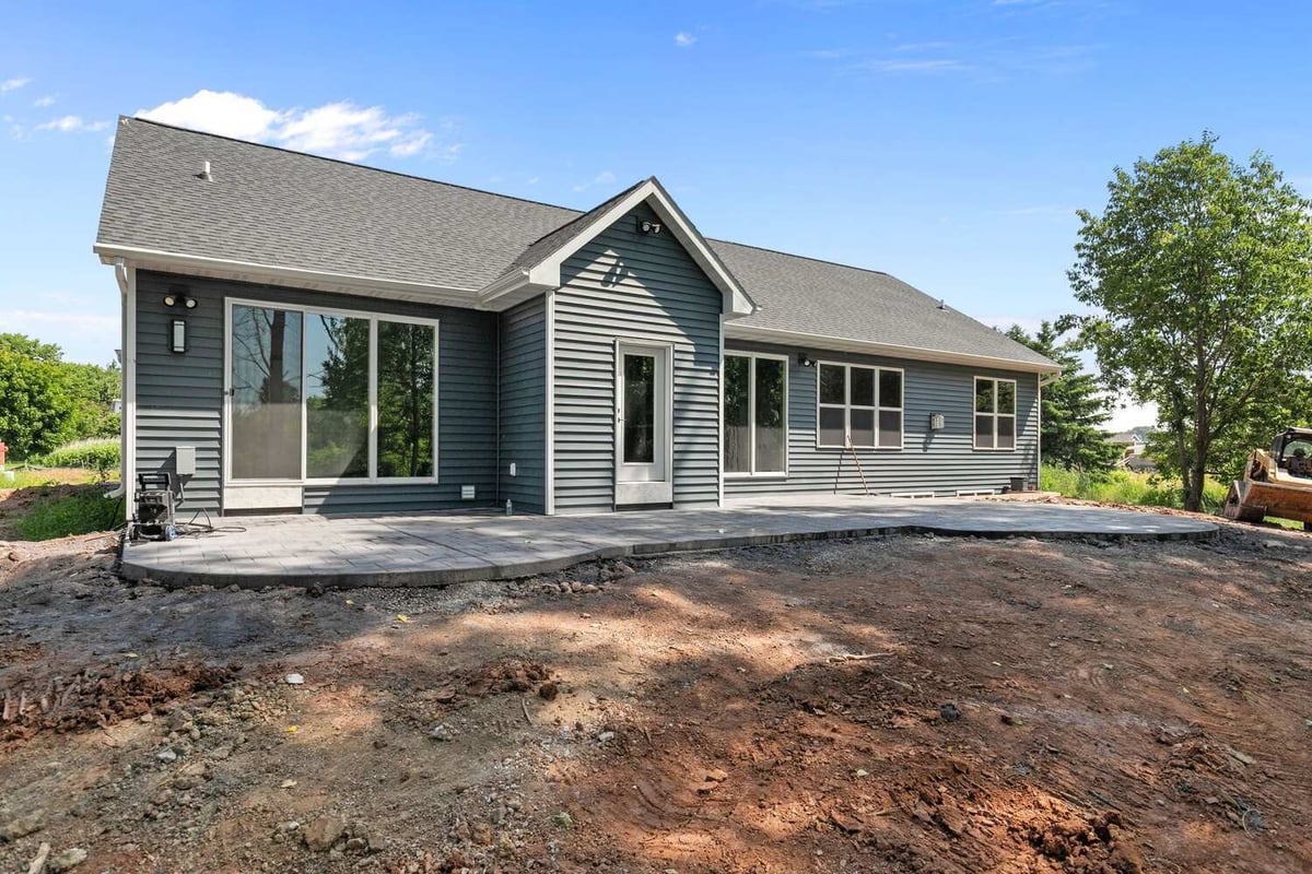 Back view of WI custom home with patio and large windows by Midwest Design Homes