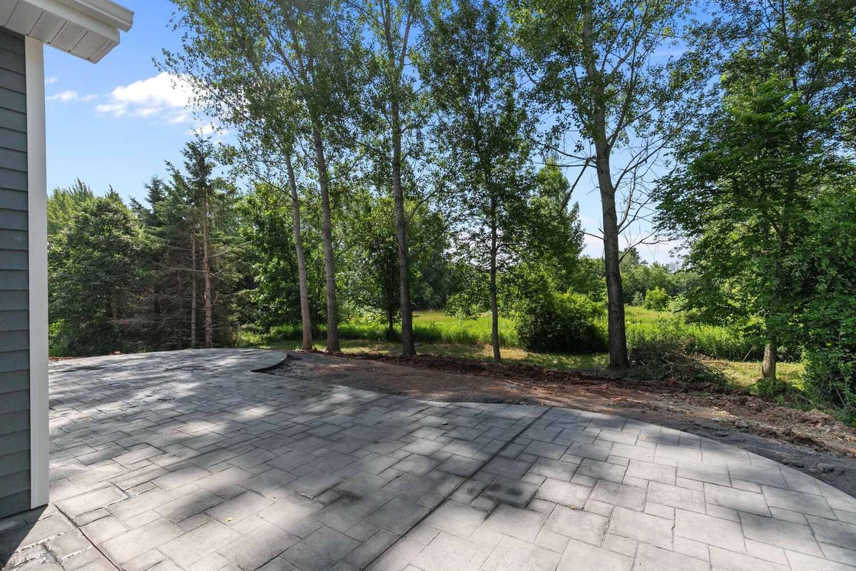 Backyard patio surrounded by trees in WI home by Midwest Design Homes