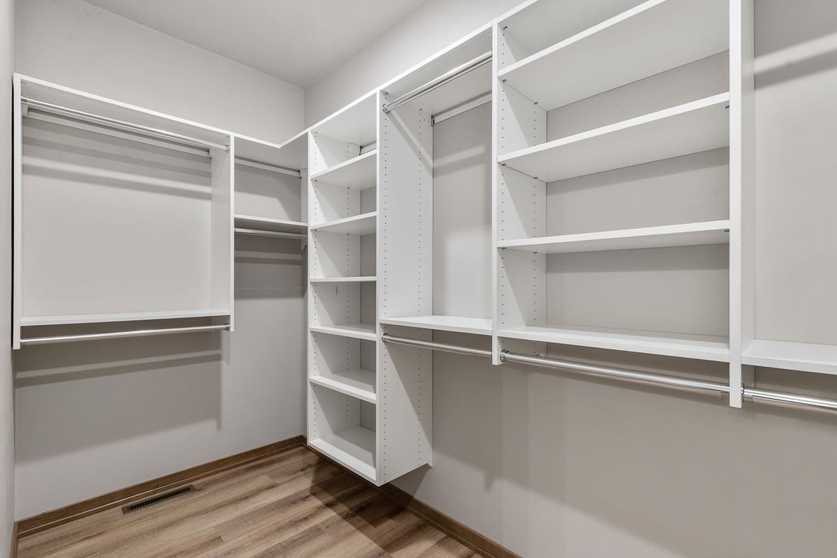 Custom walk-in closet with white shelving by Midwest Design Homes in Harrison, WI