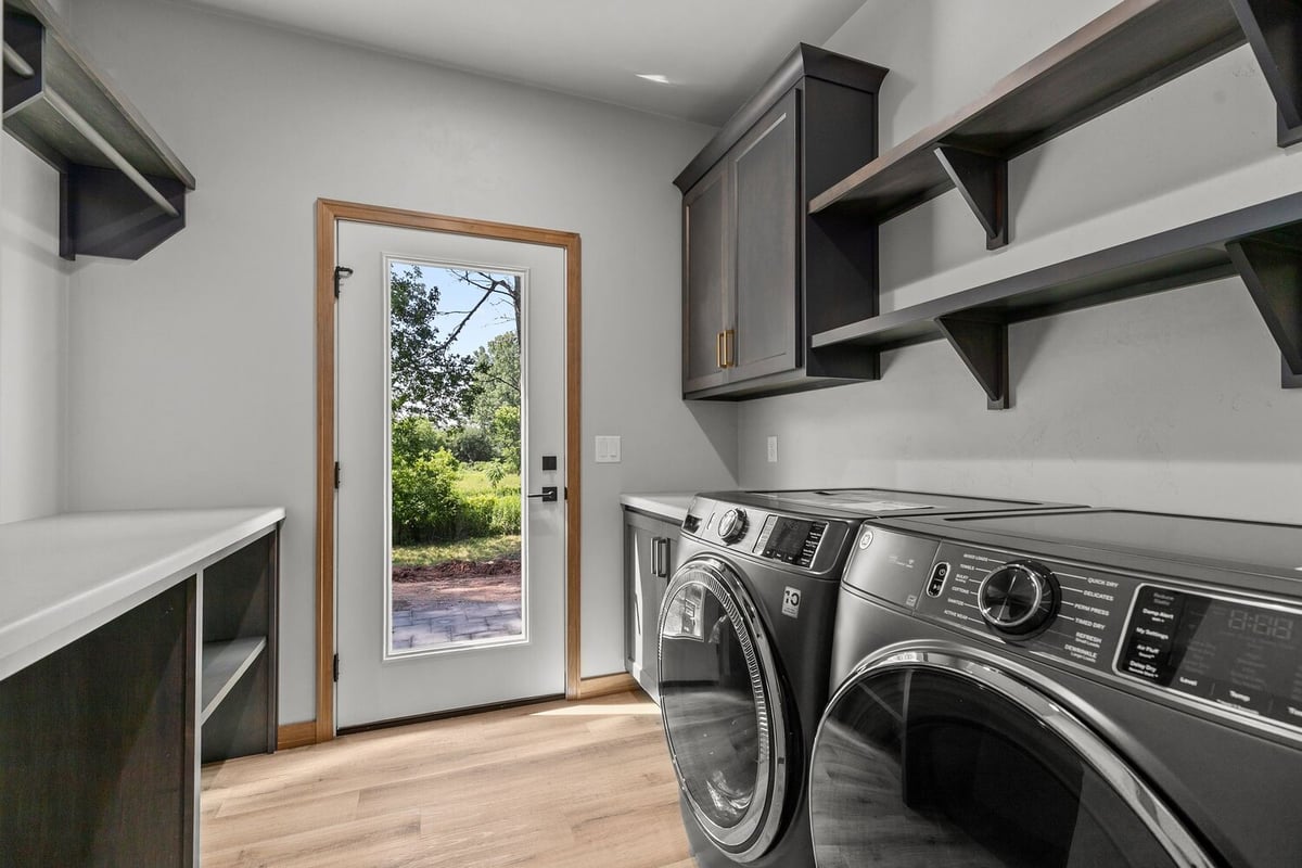 De Pere laundry room with dark cabinets by Midwest Design Homes custom home build