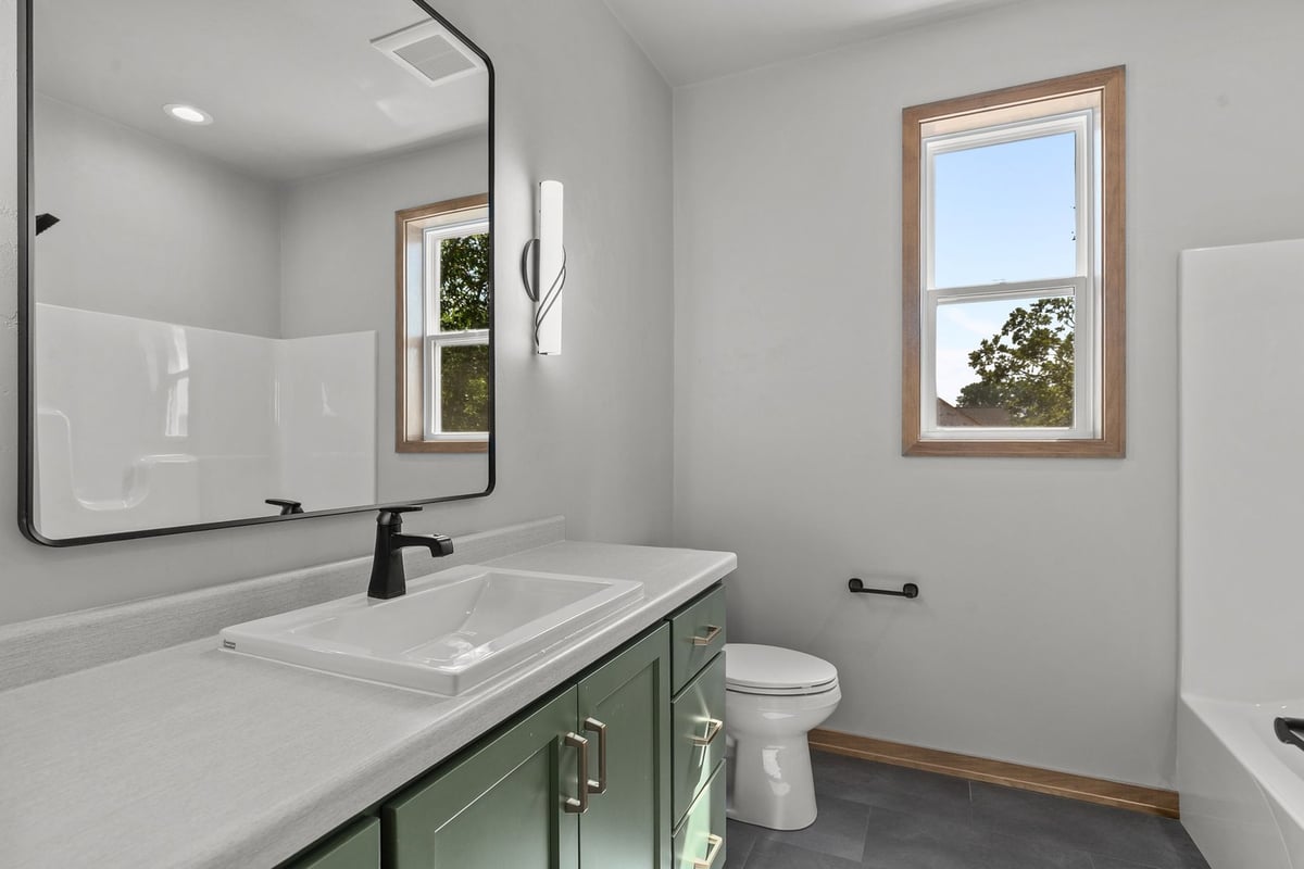 Double vanity bath with green cabinetry by Midwest Design Homes in Fremont, WI