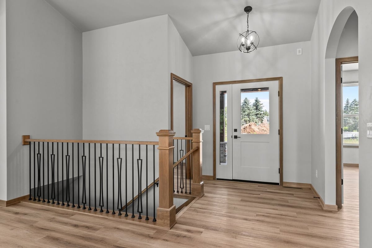 Entry and stair landing with wood and iron railing by Midwest Design Homes