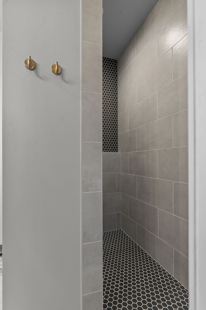 Gray tile shower with niche by Midwest Design Homes in Appleton, Wisconsin