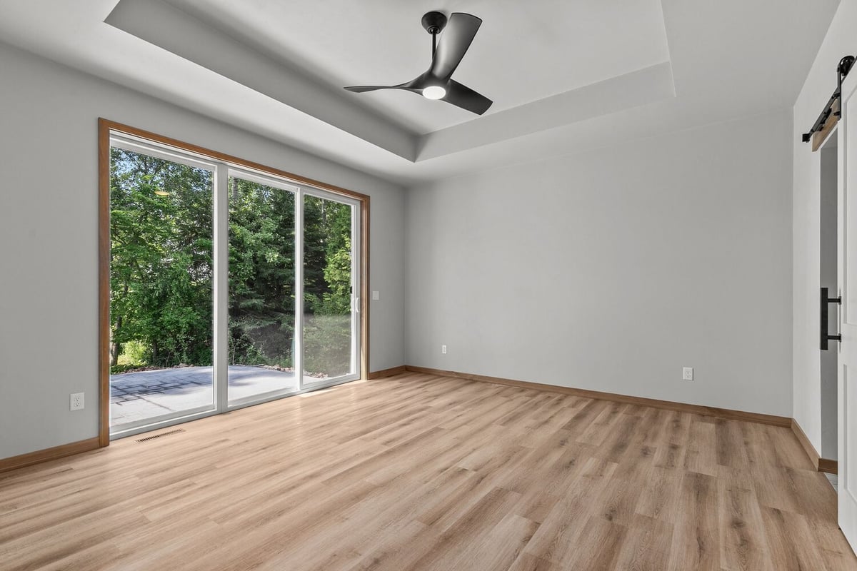 Green Bay custom bedroom with ceiling fan and large windows by Midwest Design Homes