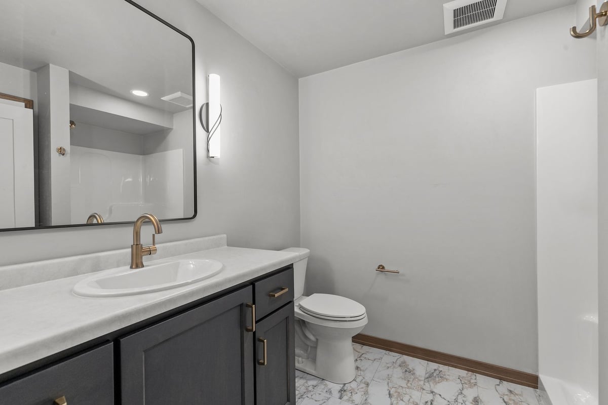 Guest bathroom with marble tile flooring by Midwest Design Homes in Wisconsin