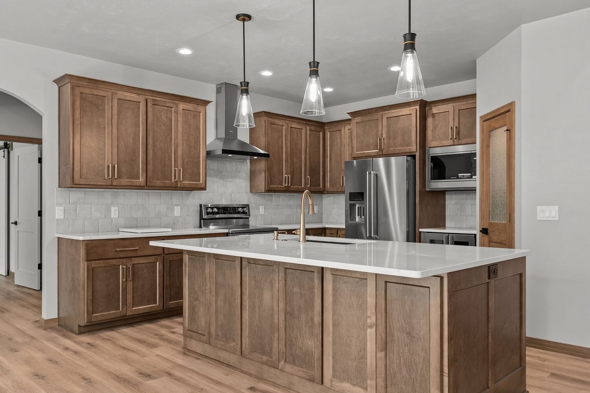 Kaukauna custom kitchen by Midwest Design Homes with pendant lights and tile backsplash