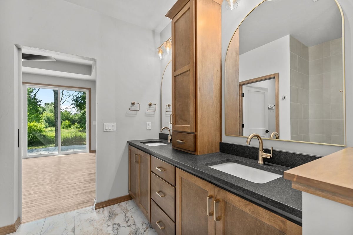 Master bath with dual vanity and black counters by Midwest Design Homes in Neenah, WI