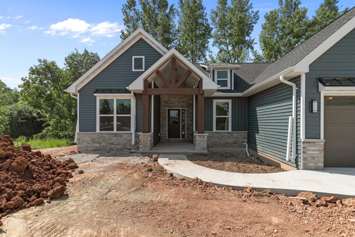 Stone and blue siding exterior entry in WI custom home by Midwest Design Homes