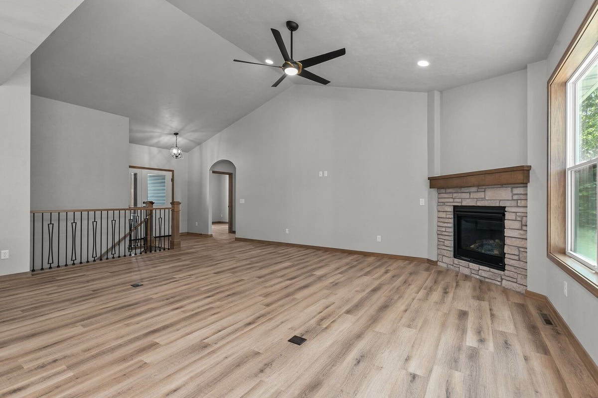 Vaulted ceiling living room with stone fireplace by Midwest Design Homes in Wisconsin