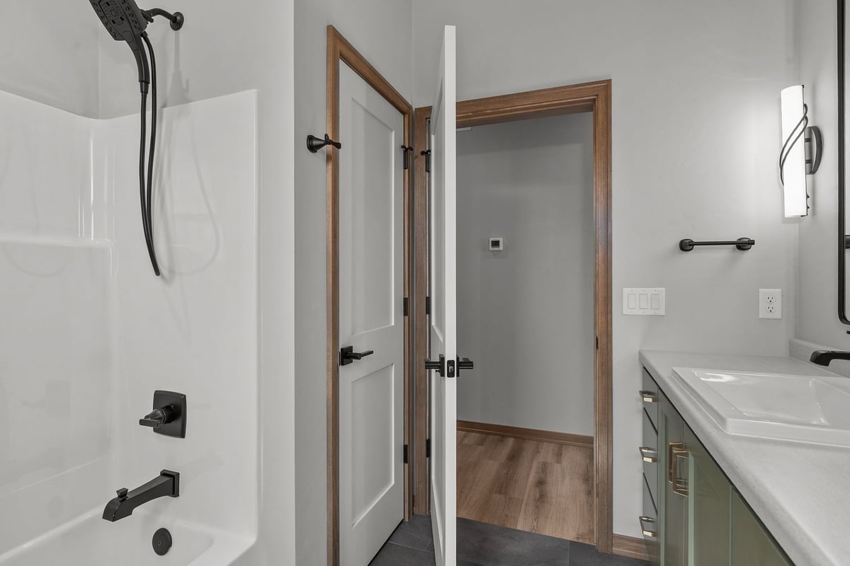 White tub shower combo with black faucet by Midwest Design Homes in Greenville, WI