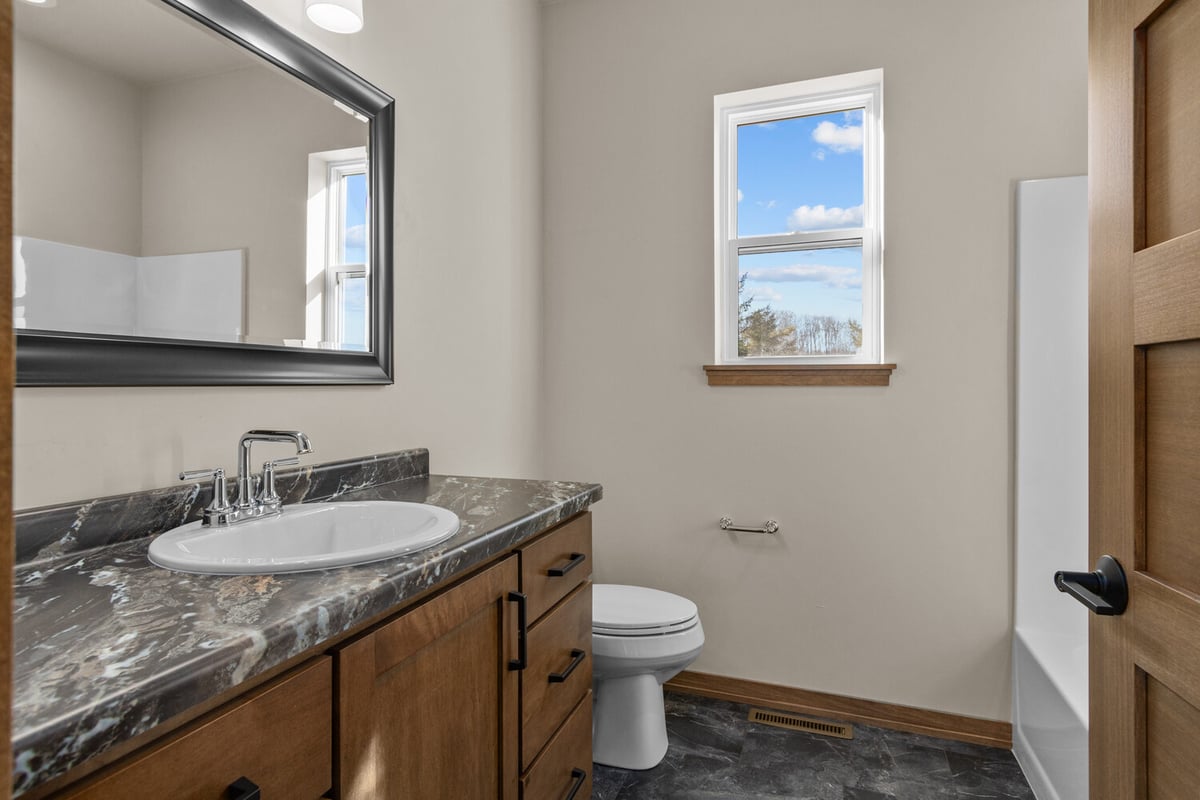 Bathroom with marble vanity in Fremont, WI custom home by Midwest Design Homes