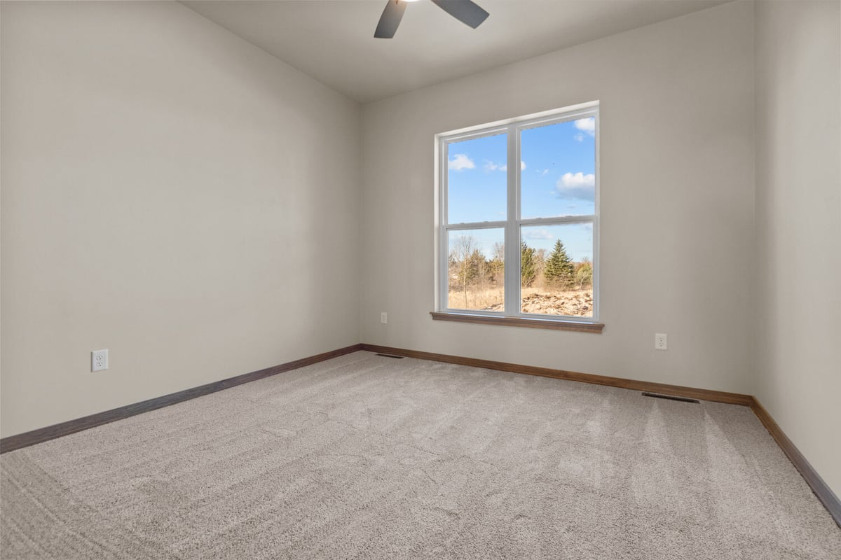 Bedroom with large window in Ledgeview, WI custom home by Midwest Design Homes