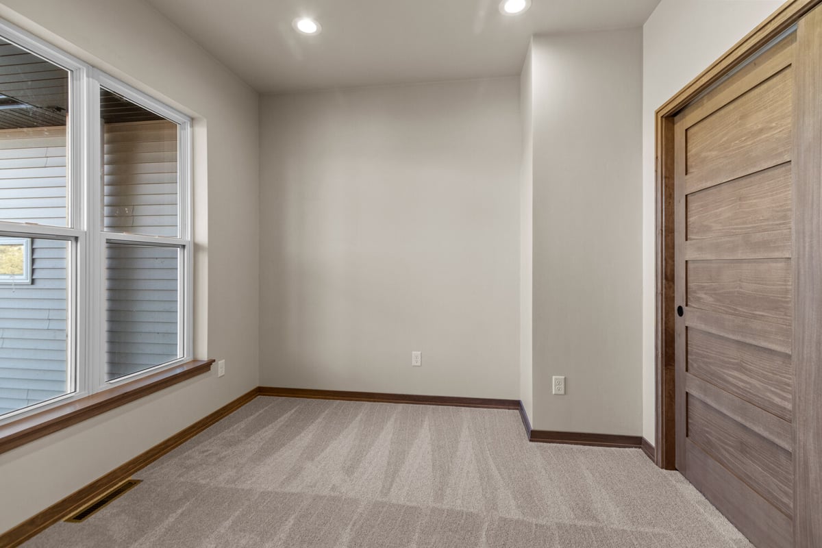 Carpeted office or den with large window in Greenville, WI custom home by Midwest Design Homes