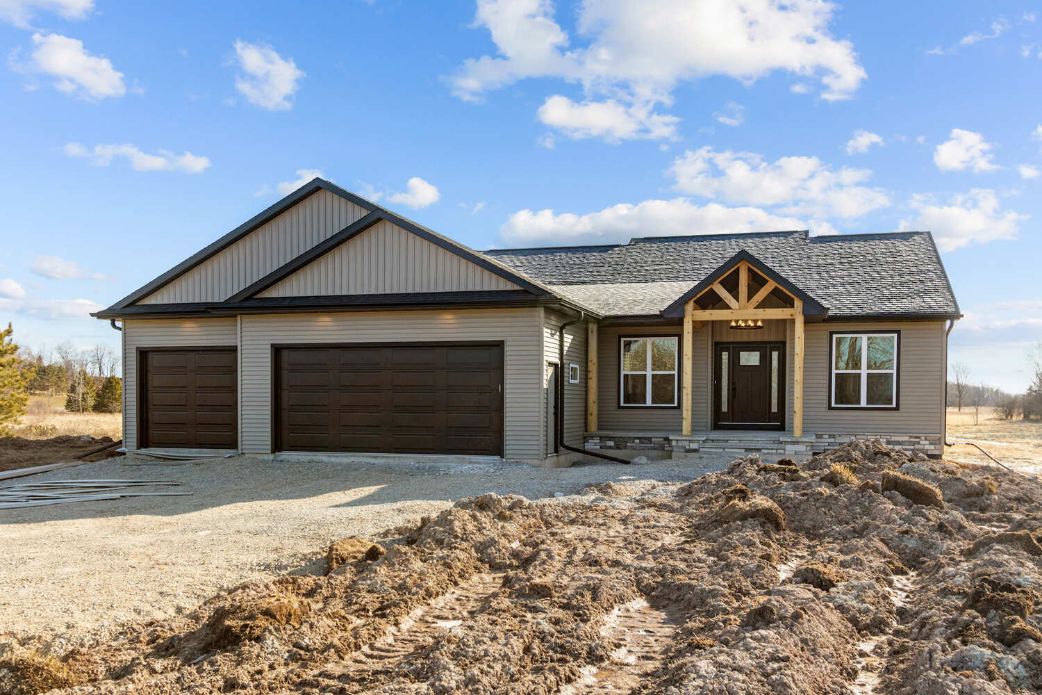 Custom Wisconsin home by Midwest Design Homes with brown garage doors and wood beams