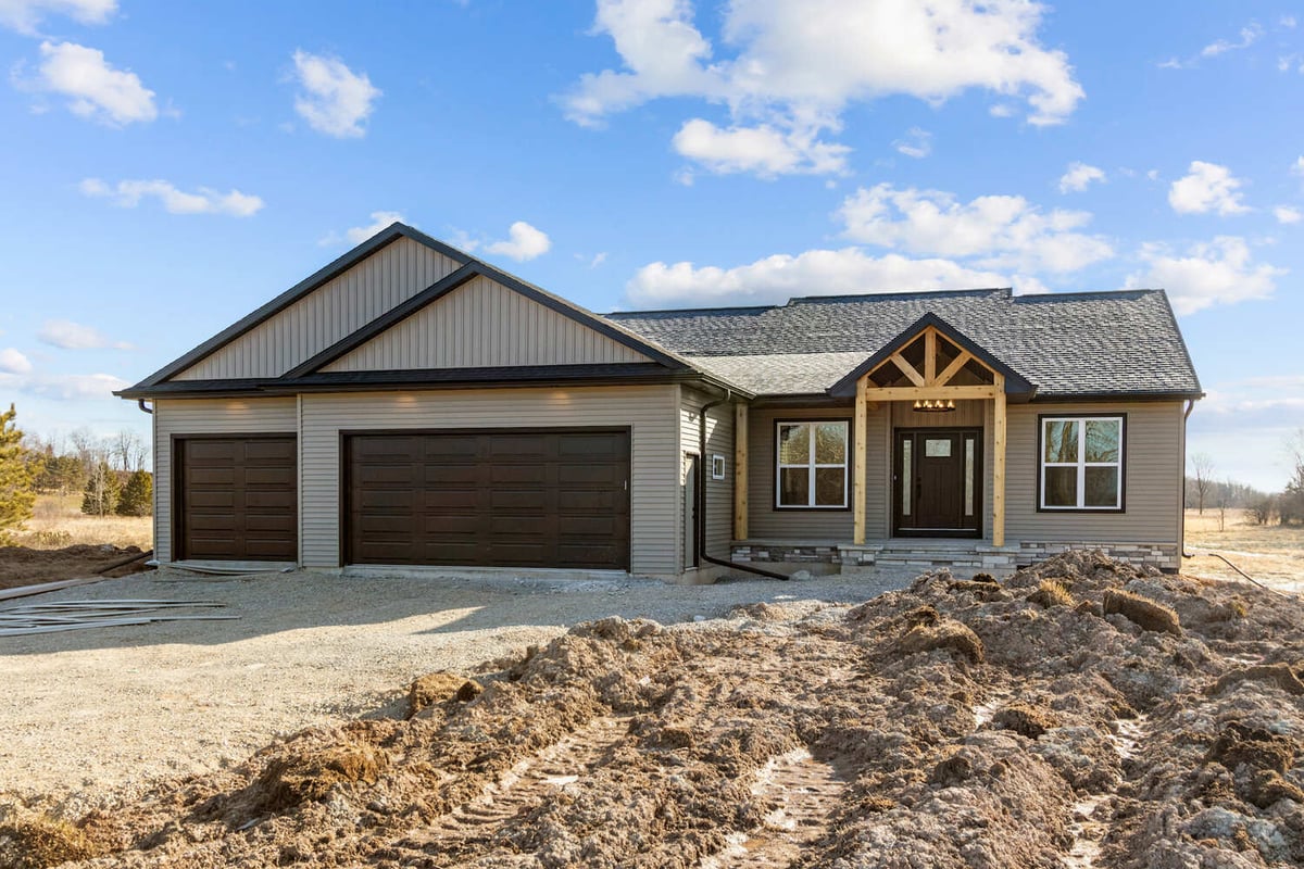 Custom Wisconsin home by Midwest Design Homes with brown garage doors and wood beams