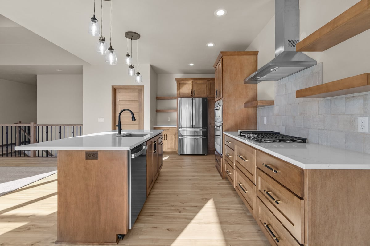 Custom kitchen with island, gas range, and hood in Kaukauna, WI by Midwest Design Homes