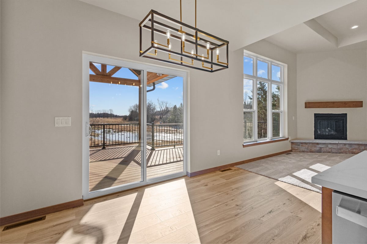 Dining area with sliding glass doors and fireplace in De Pere, WI custom home build