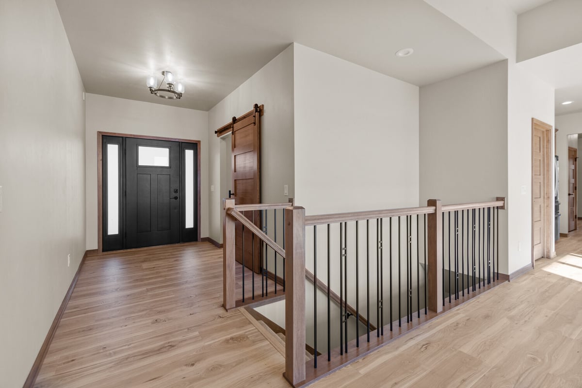 Entry with black door and stair railing in custom home by Midwest Design Homes in Wisconsin