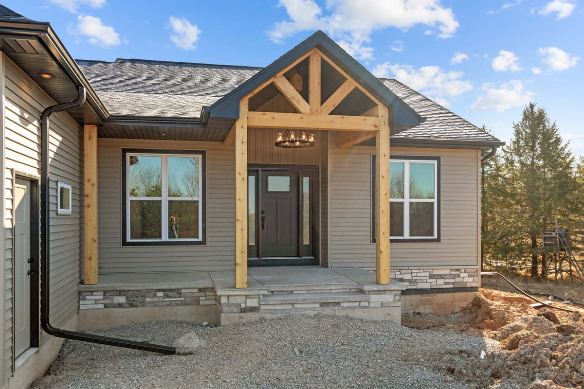 Front porch with stone steps and chandelier in WI home by Midwest Design Homes