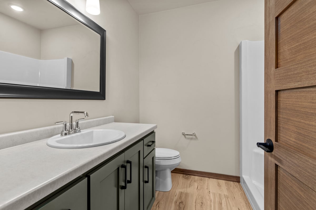 Guest bathroom with dark cabinetry in Lawrence, WI custom home by Midwest Design Homes