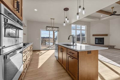Kitchen island and fireplace view in Greenville, WI custom home by Midwest Design Homes
