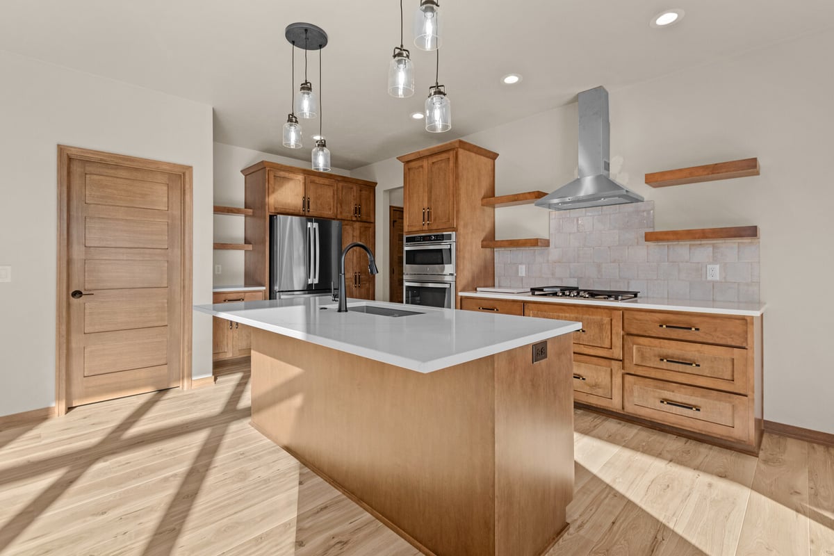 Open kitchen layout with island and double ovens in Fremont, WI by Midwest Design Homes