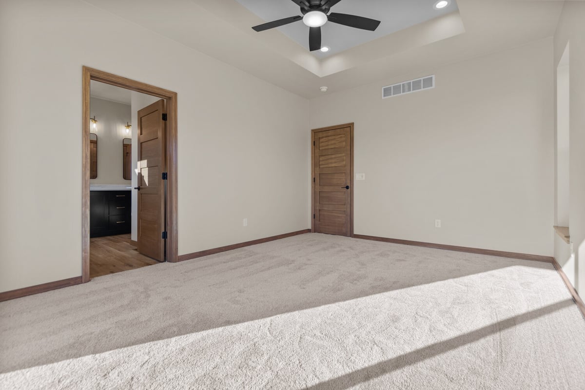 Primary bedroom leading to bath in Kaukauna home by Midwest Design Homes