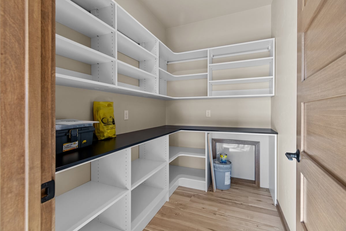 Walk-in pantry with white shelving in Harrison, WI custom home by Midwest Design Homes