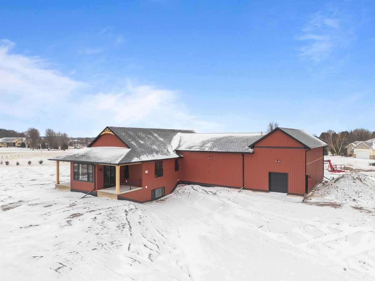 Aerial view of snowy red custom home in Kaukauna by Midwest Design Homes, Wisconsin