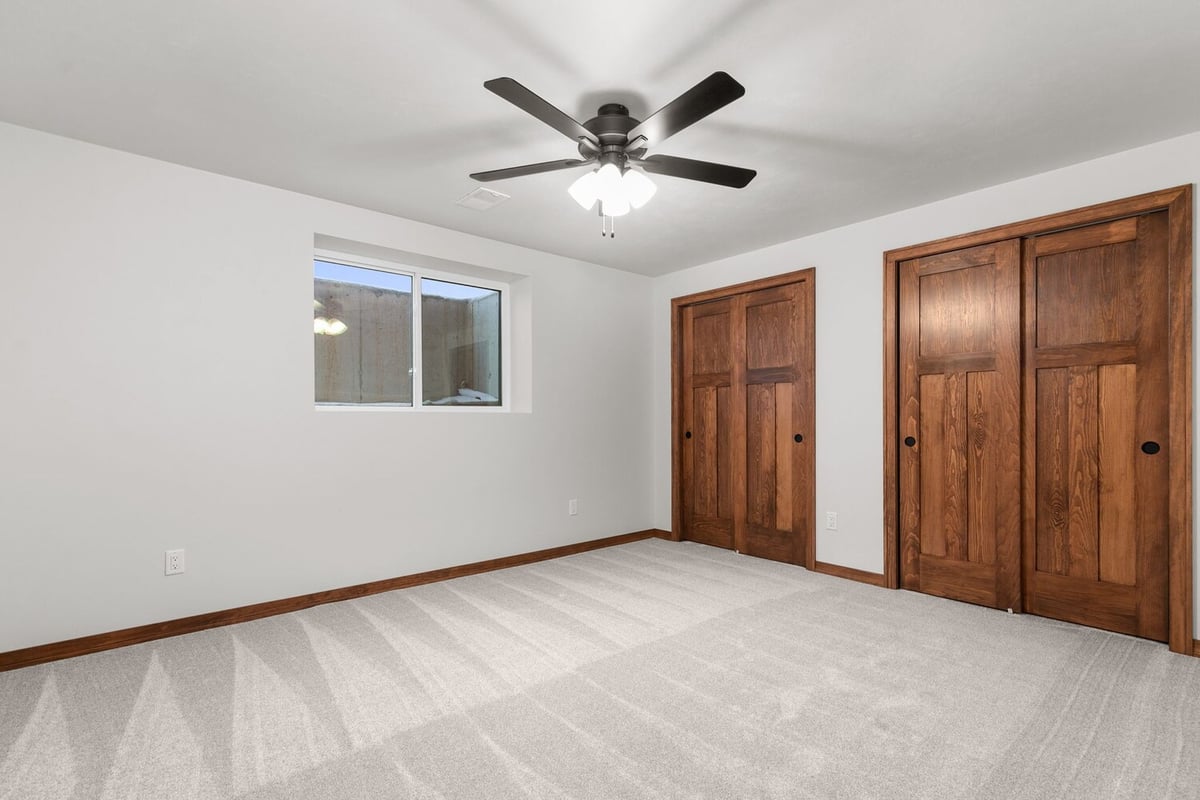 Basement bedroom with wood closets in Kaukauna home by Midwest Design Homes