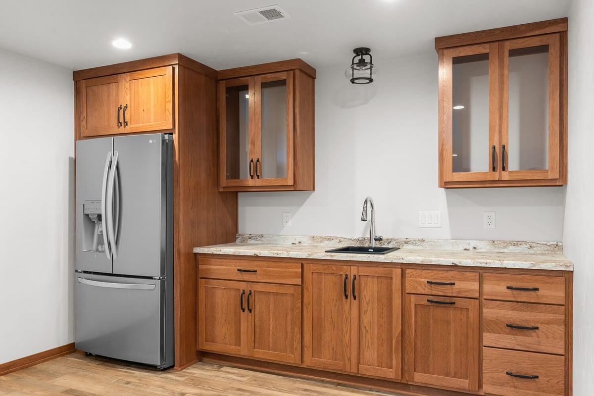 Basement kitchenette with stainless fridge in Kaukauna home by Midwest Design Homes
