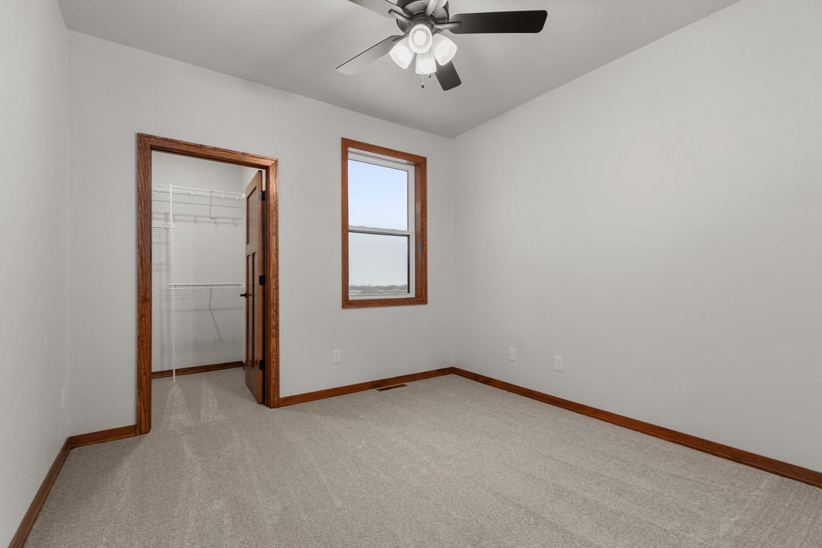 Carpeted bedroom with walk-in closet by Midwest Design Homes in Kaukauna, Wisconsin