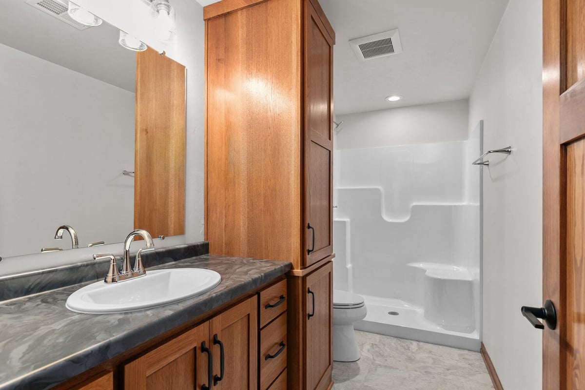 Custom bathroom with marble vanity and wood cabinets in Kaukauna by Midwest Design Homes