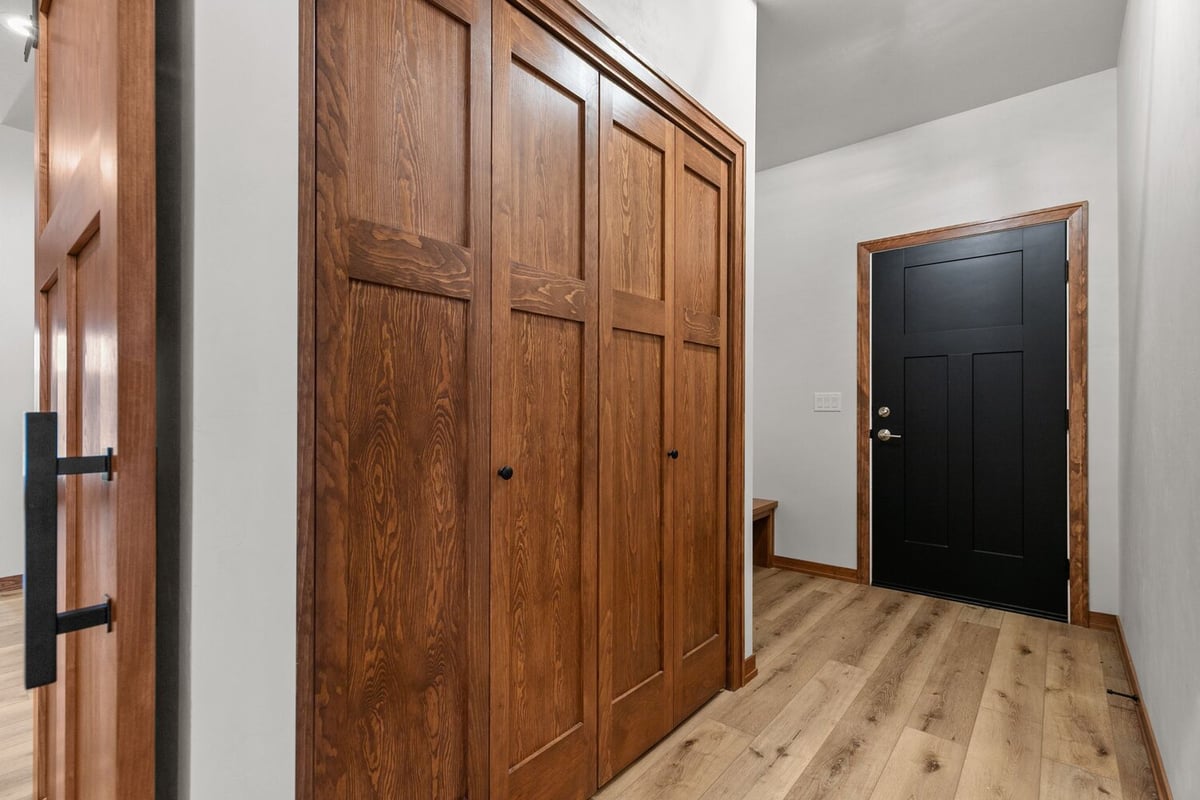 Entry hallway with wood closet doors in custom Kaukauna, WI home by Midwest Design Homes