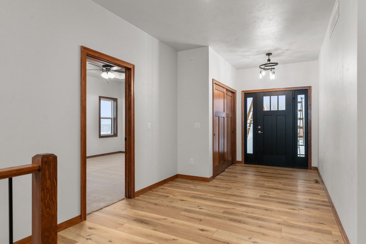 Entryway of Kaukauna custom home by Midwest Design Homes with wood floors and doors