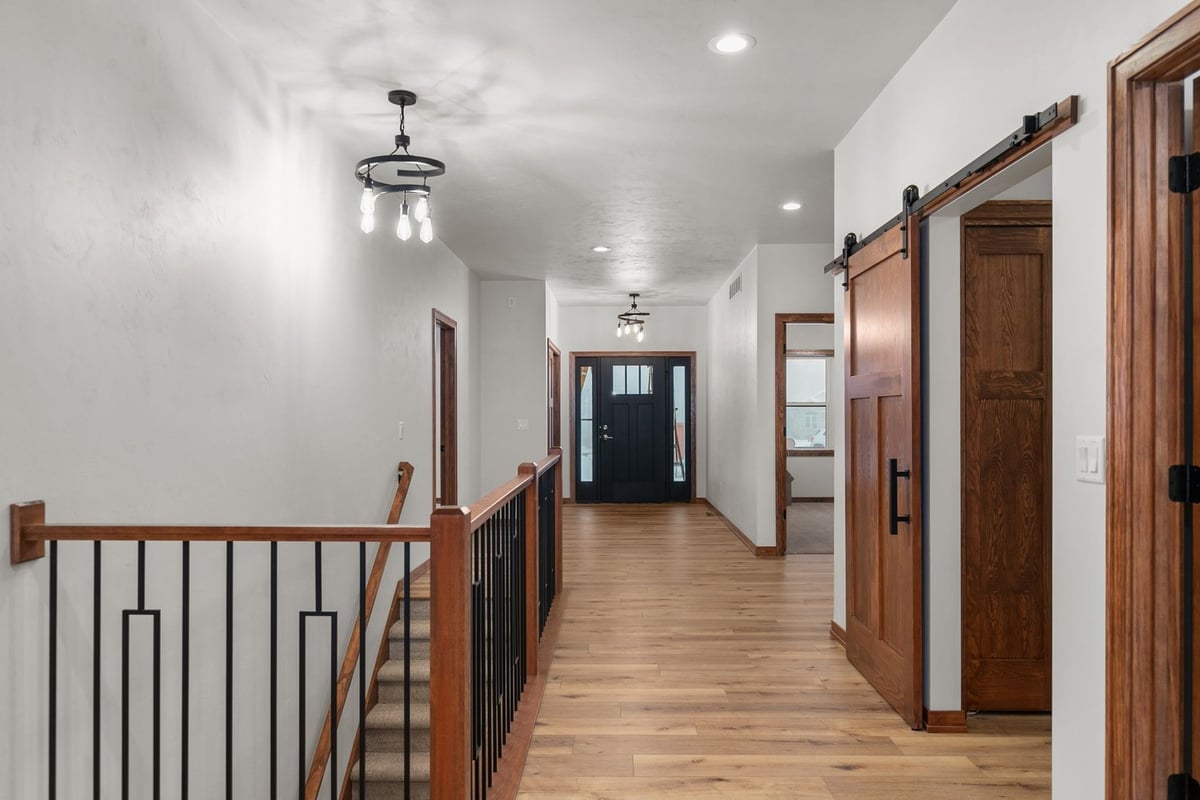 Hallway and stairway with modern lighting in Kaukauna home by Midwest Design Homes