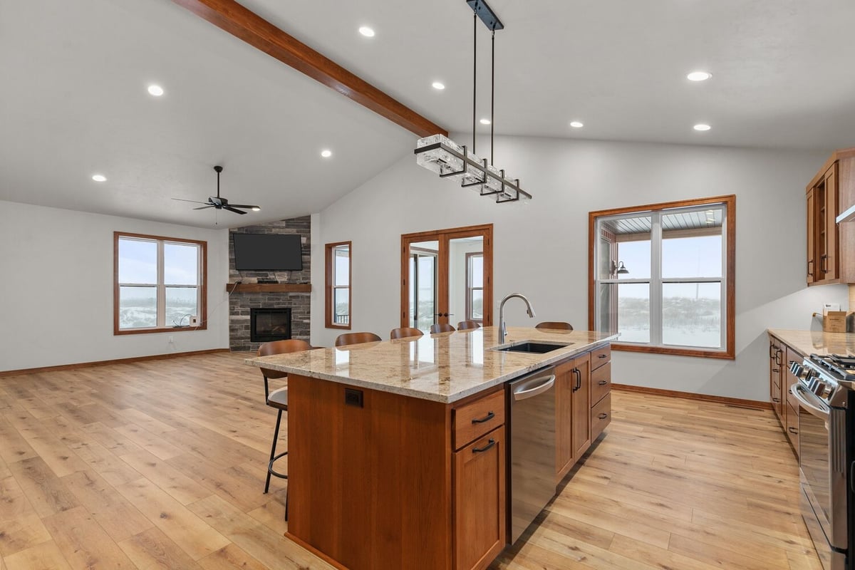 Kitchen island and living room in custom Kaukauna home by Midwest Design Homes