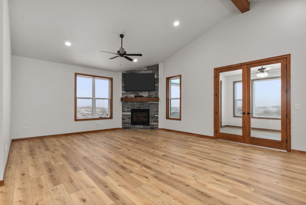 Living room with fireplace and French doors in custom Kaukauna home by Midwest Design Homes