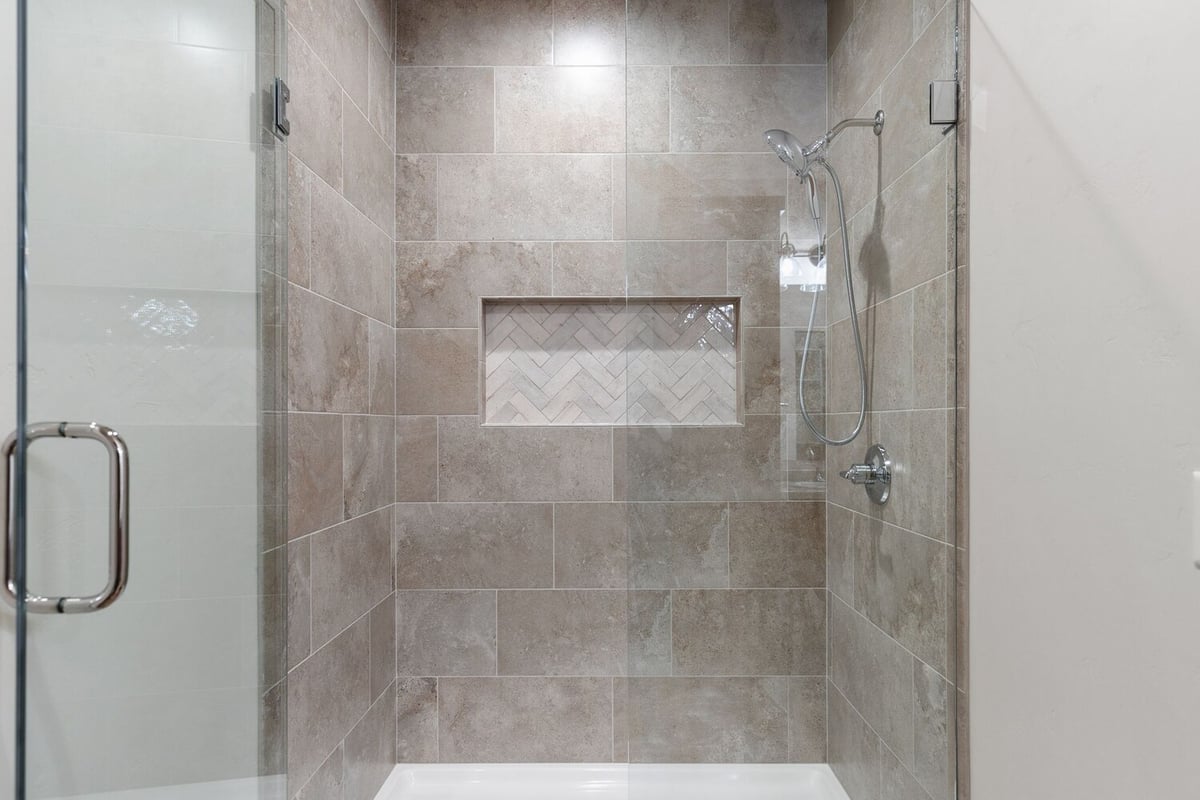 Walk-in shower with decorative tile in Kaukauna custom home by Midwest Design Homes
