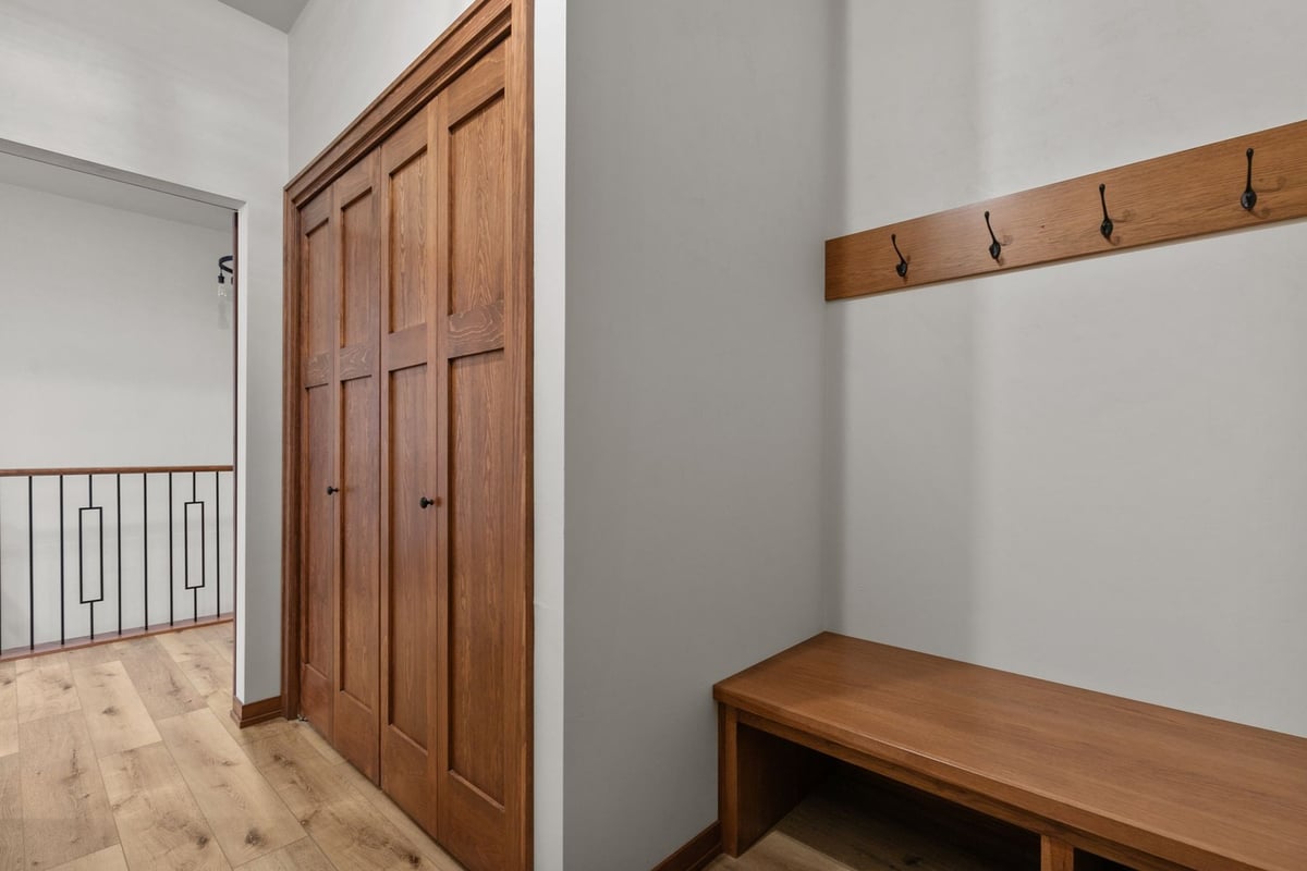 Wood bench and hooks in Kaukauna mudroom by Midwest Design Homes, Wisconsin