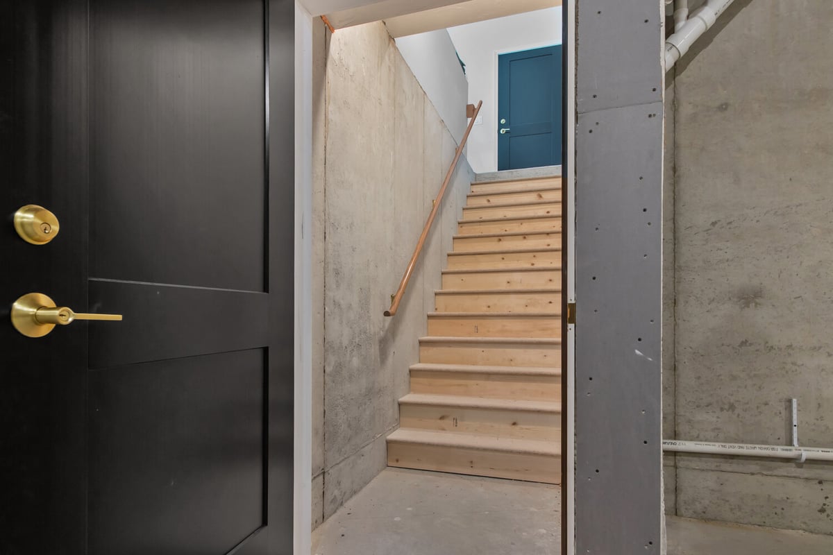 Basement stairs with wood railing by Midwest Design Homes in Green Bay, Wisconsin