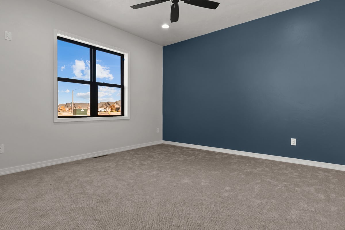 Custom home bedroom with blue accent wall by Midwest Design Homes in Harrison, WI