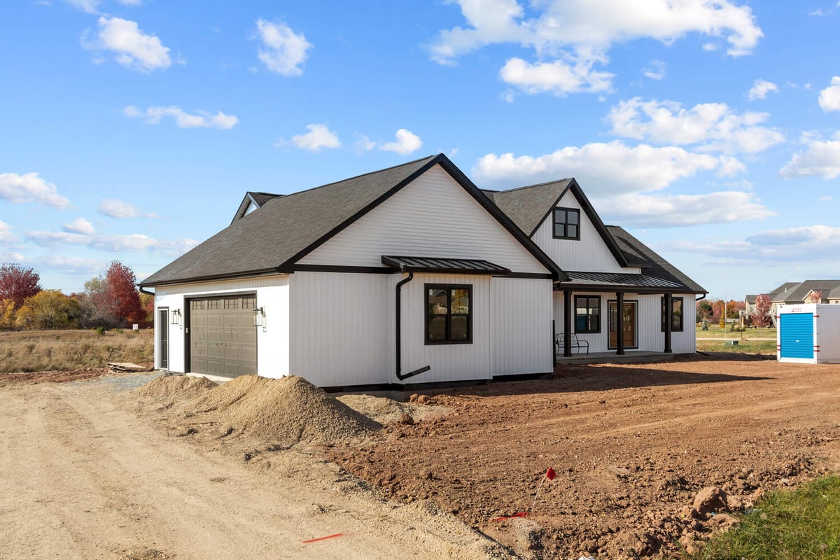 Custom white siding home with black trim in Kaukauna, WI by Midwest Design Homes
