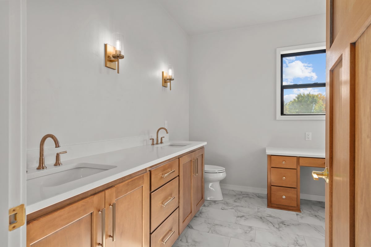 Elegant bath remodel featuring dual vanity by Midwest Design Homes in Harrison, Wisconsin