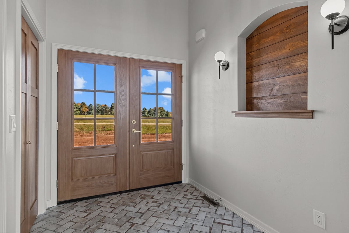 Entryway with double wood doors and brick floor by Midwest Design Homes in Kaukauna, WI