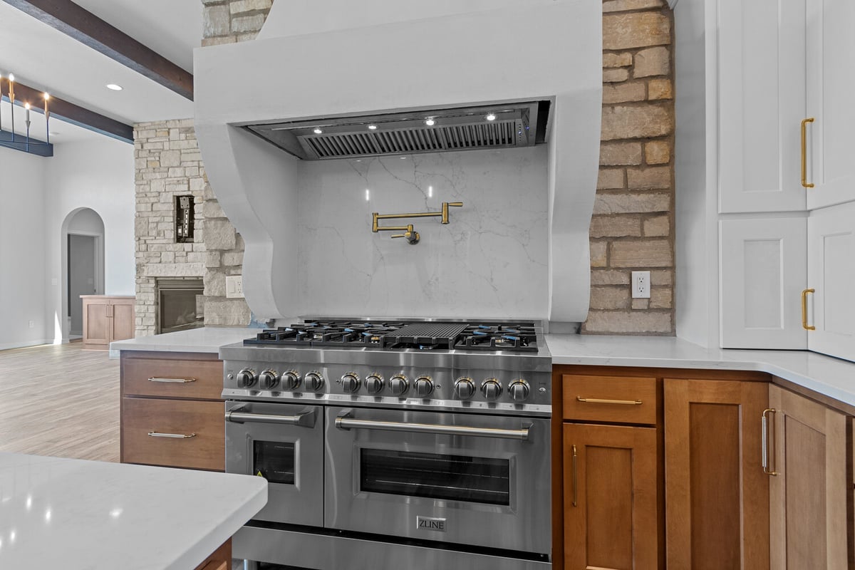 Luxury gas range with stone backsplash in custom home by Midwest Design Homes in Appleton WI