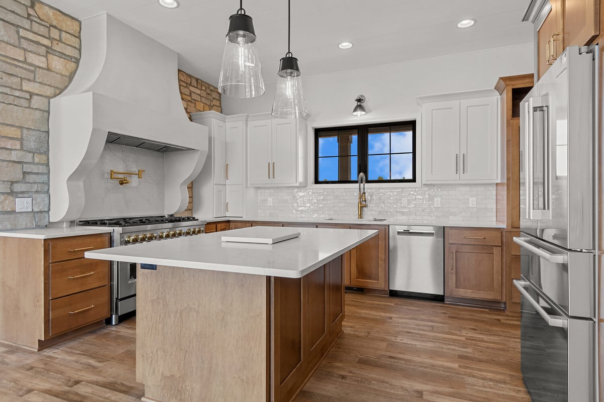 Spacious custom kitchen in Fox Cities WI with island and pendant lights by Midwest Design Homes